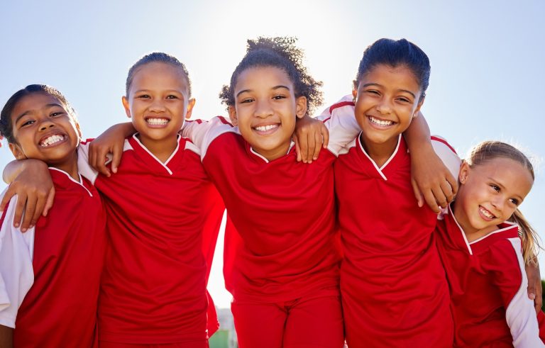 Group portrait, girl football and field with smile, team building motivation or solidarity at sport